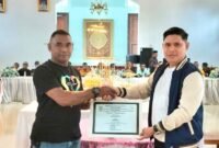 Kapala Inspektorat, Kamarudin Mahdi saat memberikan piagam penghargaan kepada Kades Modapuhi yang berhasil keluar sebagai juara desa bersih.