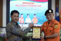 Bupati Halmahera Timur, Ubaid Yakub menerima cendramata dari Kepala Kantor Pencarian dan Pertolongan (Basarnas) Kelas B Ternate, Iwan Ramdani. || Foto : Humas SAR