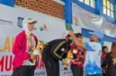 Kepala Dinas Pemuda dan Olahraga Maluku Utara, Syaifuddin Djuba mengalungkan medali kepada salah satu peserta peraih medali emas. || foto : Dispora Malut