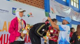 Kepala Dinas Pemuda dan Olahraga Maluku Utara, Syaifuddin Djuba mengalungkan medali kepada salah satu peserta peraih medali emas. || foto : Dispora Malut