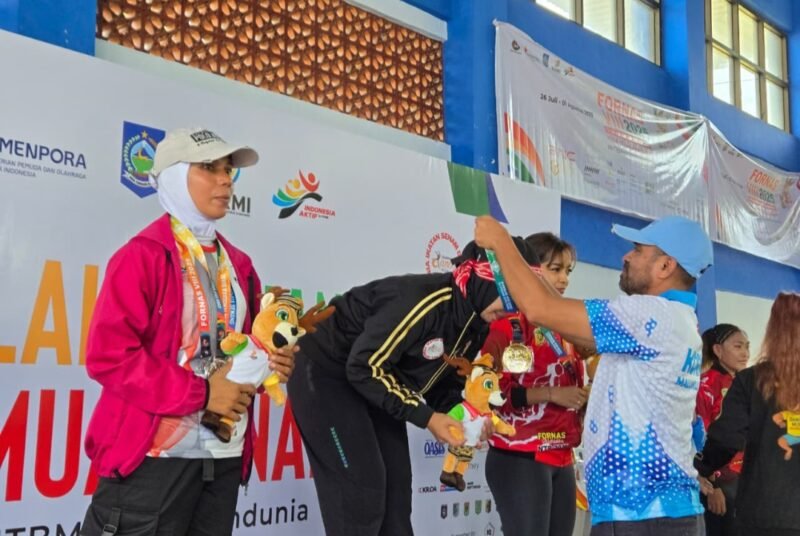 Kepala Dinas Pemuda dan Olahraga Maluku Utara, Syaifuddin Djuba mengalungkan medali kepada salah satu peserta peraih medali emas. || foto : Dispora Malut