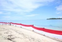 Aksi pembentangan bendera merah putih sepanjang 80 meter di wilayah Maritim dekat Pulau Jiew, yang mencakup Pulau Liwo dan Pulau Sayafi. || dok : Sukarsi/Kasedata