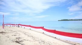 Aksi pembentangan bendera merah putih sepanjang 80 meter di wilayah Maritim dekat Pulau Jiew, yang mencakup Pulau Liwo dan Pulau Sayafi. || dok : Sukarsi/Kasedata