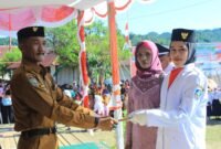 Pejabat Kepala Desa (Pj Kades) Fofau Ikram Samsudin menyerahkan bonus uang saku kepada salah satu anggota Paskibraka asal Dusun Pasir Putih, Desa Fofau, Kayoa Barat. || dok : Kasedata