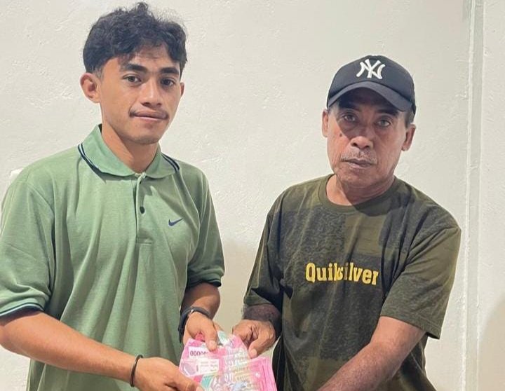 Kaur Keuangan Desa Kokotu, Muamar Arman saat menyerahkan gaji dan insentif para perangkat desa. || dok : Ridal Lahani/KASEDATA.ID