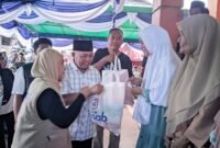 Founder Nasab Foundation, Nasri Abubakar, saat memberikan bantuan paket sembako kepada penerima [Foto : sukarsi/kasedata]