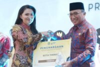 Wali Kota Ternate Tauhid Soleman saat menerima penghargaan dari Gubernur Maluku Utara Sherly Tjoanda pada kegiatan Musrenbang RKPD 2027 [ Foto : istimewa]
