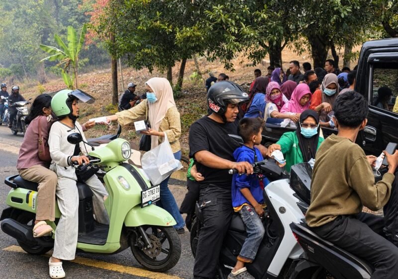 Jajaran pengurus Fatayat NU Maluku Utara turun membagikan masker kepada warga dan pengguna jalan yang melintas di sepanjang ruas Takome–Sulamadaha. || Foto : Kasedata.id
